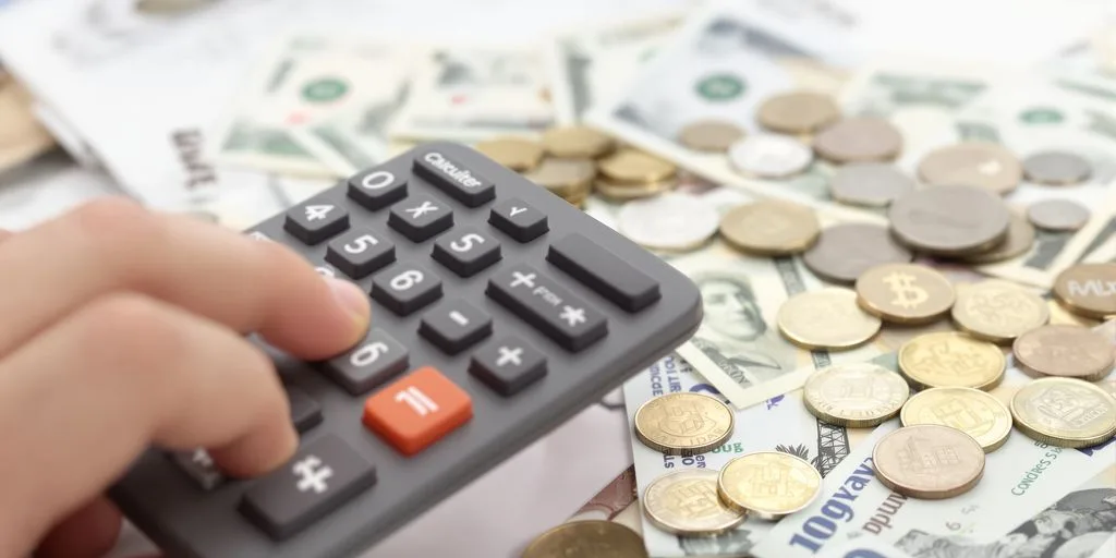 Calculadora financiera con dinero y documentos.