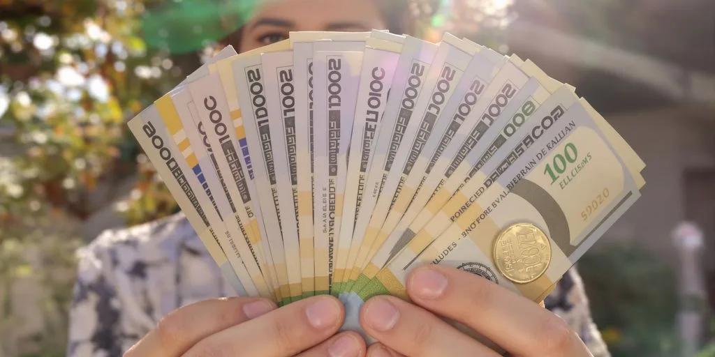 Persona sonriendo con dinero en mano.